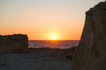 Sunset over Gozo Island Limestone Cliffs and Mediterranean Sea Waves.