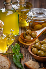 Olive oil in glass bottle and olives