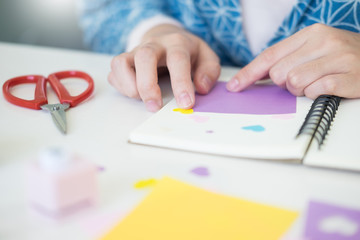 Woman's hand cut paper Making a scrap booking or other festive decorations DIY accessories arrangement.