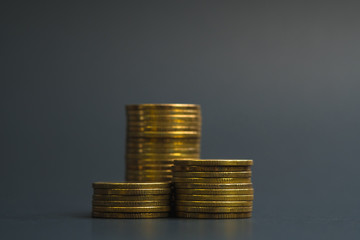 Savings, increasing columns of coins, piles of coins arranged as a graph in dark room, business banking concept.