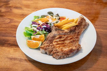 Grilled pork meat steak with oranges and vegetables