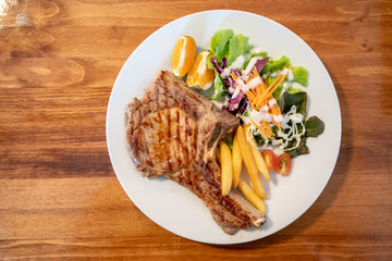 Grilled pork meat steak with oranges and vegetables