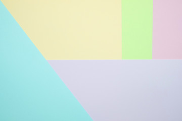 Fashionable  pastel colored paper flat lay top view, geometric background texture, pink, purple, yellow, beige, green and blue.