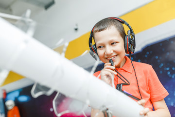 Boy child using headphones and mic at the interactive space or science museum