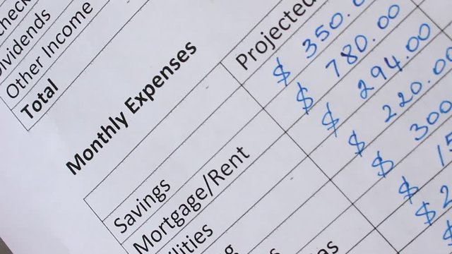 Fixed Expenses: mortgage or rent payments, utility bills, and loan payments. A man writes down all his sources of income and all expenses