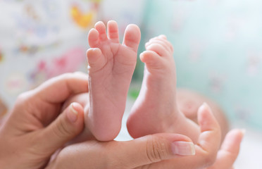 Obraz na płótnie Canvas Baby legs in mother hand