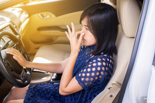 Woman hands squeeze her nose with of bad smell in a car