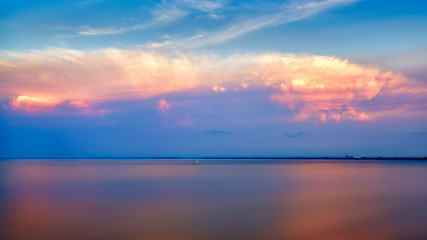 Beautiful red and pink clouds with reflection and sail boat at Lake superior