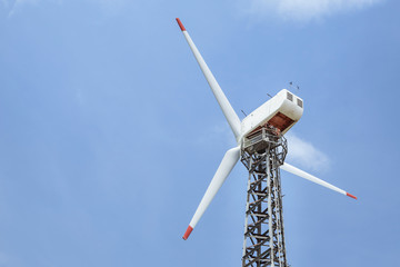 close up white wind turbine generating electricity producing in wind power station alternative...