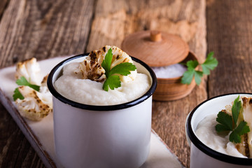 Healthy cauliflower cream soup in rural mugs