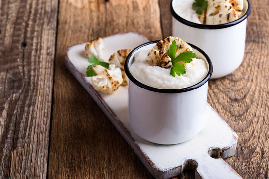 Healthy cauliflower cream soup in rural mugs