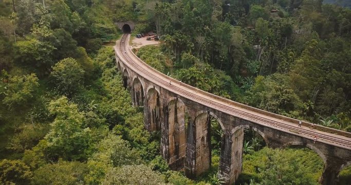 Drone flying left and turning to reveal magnificent wide panoramic aerial view of Nine Arch Bridge Ella in Sri Lanka.