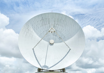 Big large white satellite dish turn up skyward on blue sky in earth communication antenna system...