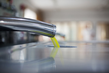 Oil is pouring from the tube at a cold-press factory after the olive harvesting in one of the cretan villages, Greece