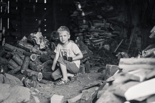 Little boy working in a shed with wood