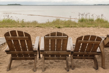 Old wooden sunbeds under a cloudy sky