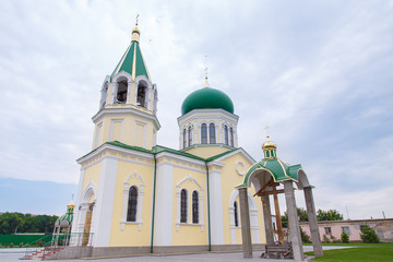 Fototapeta na wymiar church with green domes on the blue sky background