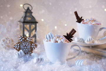Obraz na płótnie Canvas Blurred background of winter frost and Christmas chocolate spice beverage with cookies in white cups