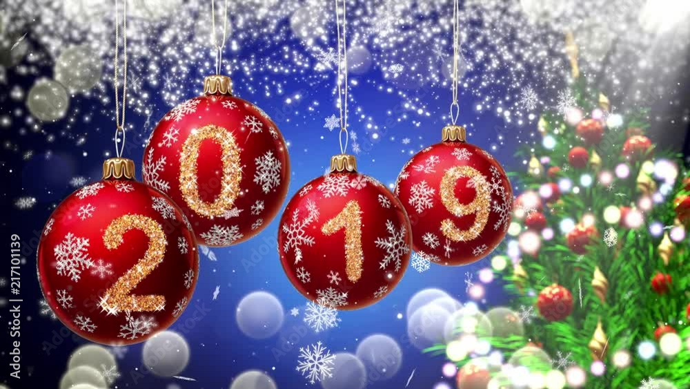 Wall mural red balls with numbers 2019 hanging on the background of a blue bokeh and a rotating christmas tree 
