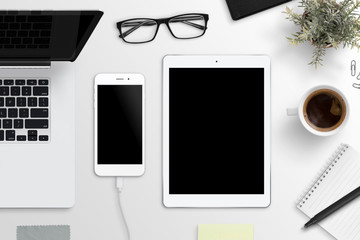 Smart phone and tablet mockup. Office desk with laptop computer, glasses, cup of coffee, notepad...