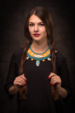 Beautiful female brunette model in handmade accessories fashion jewelry necklace. Fashion photo.