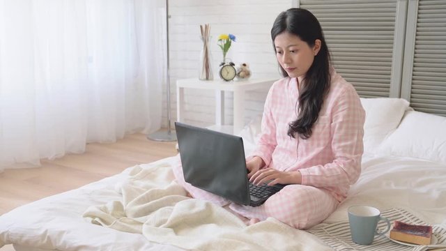 Girl using a laptop on the bed.