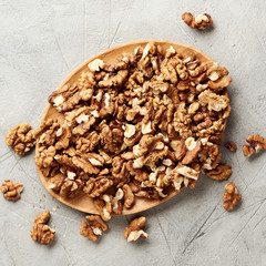 Walnut kernels on gray background and nutcracker.