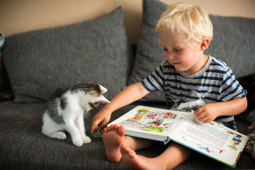 Kind spielt mit Katze