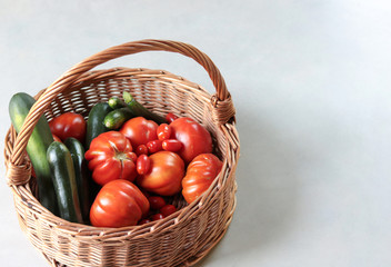 wicker basket full of fresh tomatoes and  zucchini.