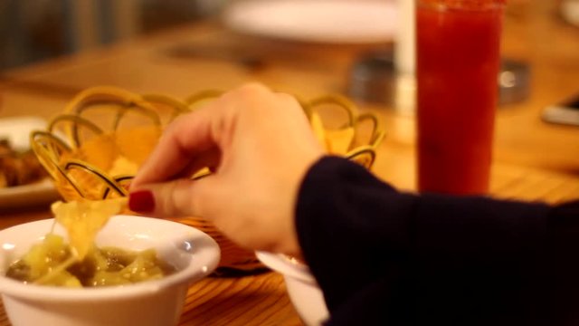Close-up, a hand grabs an totopo in some restaurant.
