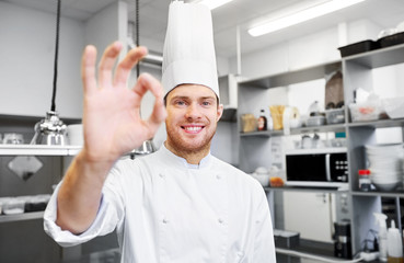 cooking, profession and people concept - happy male chef cook in toque at restaurant kitchen...