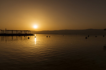 People bathing in the dead sea at sunrise