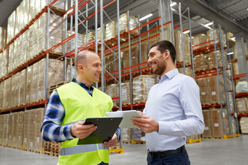 logistic business, shipment and people concept - warehouse worker and businessman with clipboard...