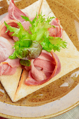 Russian pancake with ham slices close up