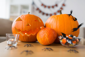 holidays, decoration and party concept - jack-o-lantern or carved pumpkin with halloween...