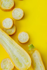 Naklejka na ściany i meble Creative layout of solid and sliced yellow zucchini on blue background with space for text.