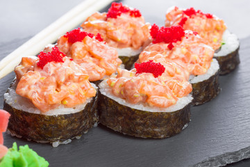 Japanese restaurant, sushi roll on black slate plate.