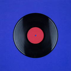 Closeup of Vinyl Long Play Record with Label with Copy Space on blue background