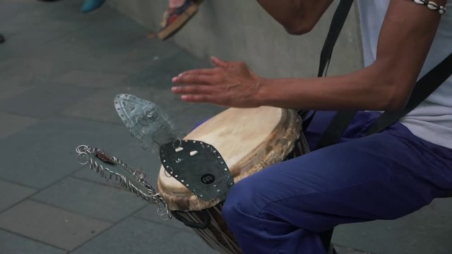 Street performer playing tabla with metal fixtures on the streets of London (Slow Motion) (Editorial)