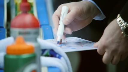 closeup trainer hand draws successful game plan at table