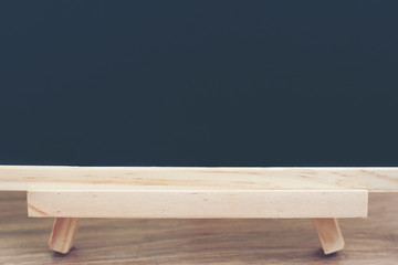  Black board on wood table top with sun and blur green tree bokeh background, Template mock up for display of product