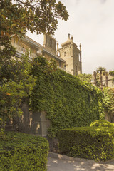 The tower and the Western facade of the Vorontsov Palace, visible from the surrounding garden with rich vegetation.Crimea.