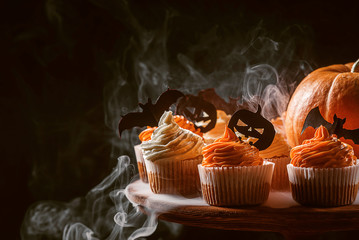 cupcake and pumpkin on a dark background. sweets for the celebration of Halloween.