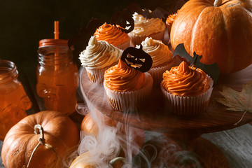 cupcake and pumpkin on a dark background. sweets for the celebration of Halloween.