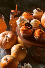 cupcake and pumpkin on a dark background. sweets for the celebration of Halloween.