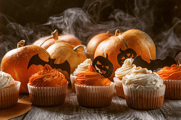 cupcake and pumpkin on a dark background. sweets for the celebration of Halloween.