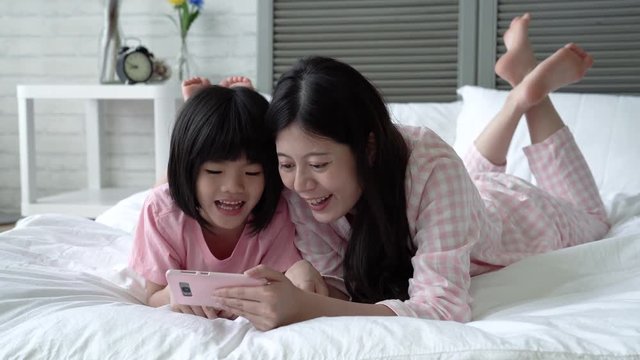 Mom plays cellphone with a daughter.