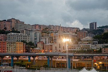 Obraz premium Panoramiczny widok na miasto Genua o zachodzie słońca.