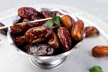 Dry fruit dates on silver tray. Copy space. Close up.
