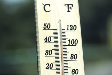 Thermometer displaying high 40 degree hot temperatures in sun summer day.